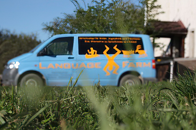 Blauer Kleintransporter mit Language Farm Aufschrift