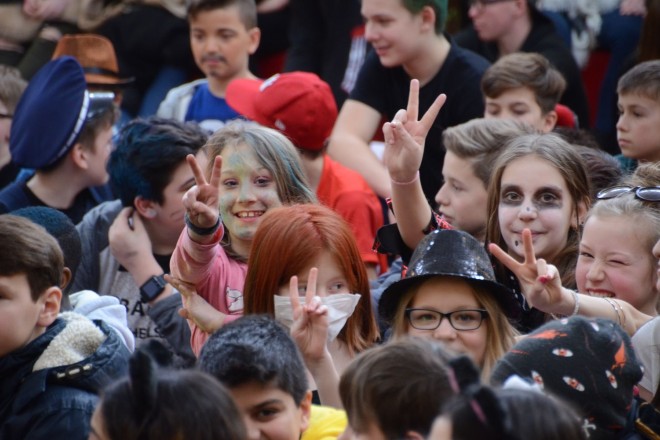 Foto zeigt verkleidete lachende Schulkinder die Peace Handzeichen machen
