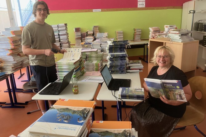 Lehrbuchverwalterin Sandra Kirsch und Tim Maier beim digitalen Erfassen der Schulbücher